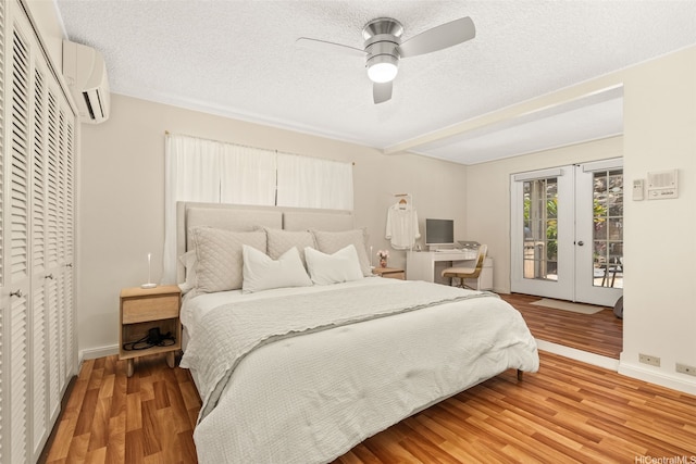 760 Onaha St, Honolulu, HI 96816 - bedroom with access to outside, a wall mounted AC, light wood-style floors, french doors, and a textured ceiling