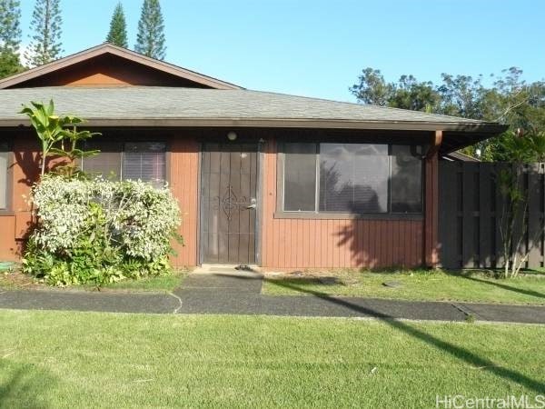 view of front facade with a sunroom, a front lawn, and fence
