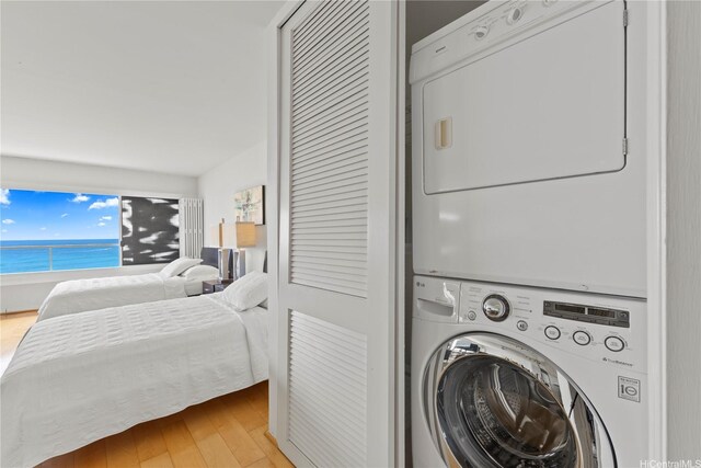 2895 Kalakaua Ave Unit 1202, Honolulu, HI 96815 - laundry room with estacked washer and dryer, light wood-type flooring, and a water view