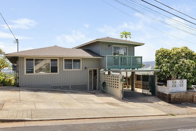 1180 Wanaka St, Honolulu, HI 96818 - view of front of property with driveway, a balcony, roof with shingles, and fence