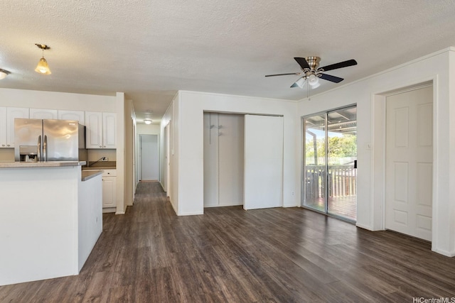 1180 Wanaka St, Honolulu, HI 96818 - unfurnished living room featuring dark wood-style flooring, a ceiling fan, a textured ceiling, and baseboards