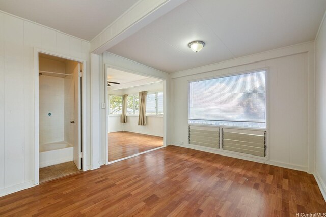 1180 Wanaka St, Honolulu, HI 96818 - empty room with wood finished floors, crown molding, a decorative wall, and baseboards