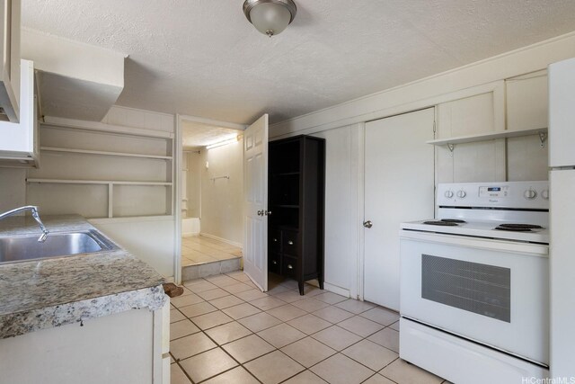 1180 Wanaka St, Honolulu, HI 96818 - kitchen featuring white range with electric stovetop, light tile patterned flooring, a sink, light countertops, and a textured ceiling