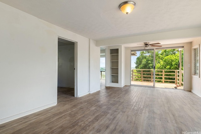 1180 Wanaka St, Honolulu, HI 96818 - empty room featuring wood finished floors, baseboards, built in features, healthy amount of natural light, and a textured ceiling