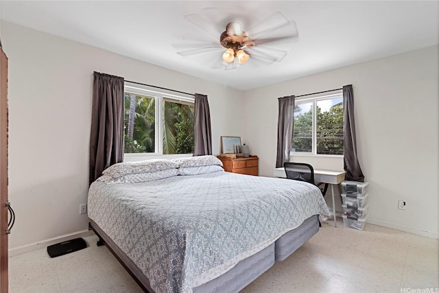 bedroom featuring a ceiling fan, baseboards, multiple windows, and light floors