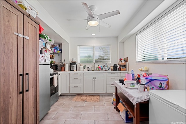 kitchen featuring ceiling fan, a sink, light countertops, light tile patterned floors, and white cabinets