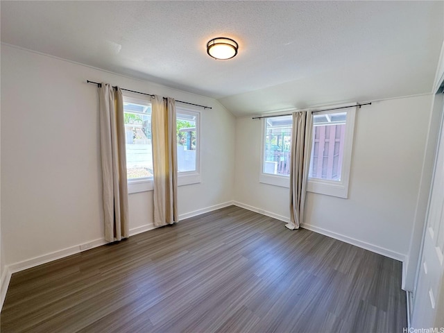 unfurnished room featuring a textured ceiling, baseboards, dark wood-style flooring, and lofted ceiling