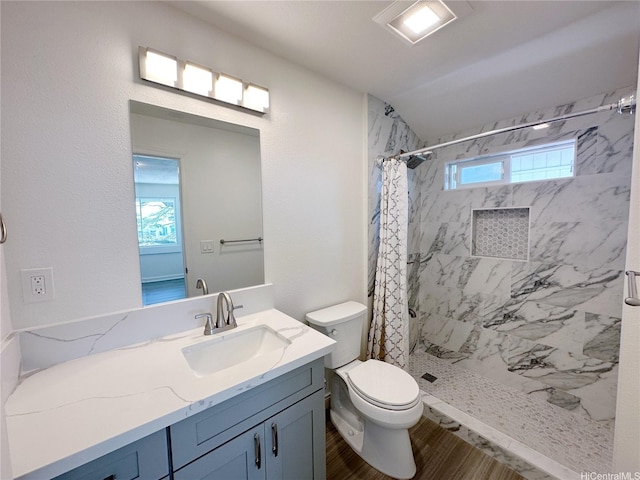 full bath featuring a shower stall, vanity, toilet, and wood finished floors