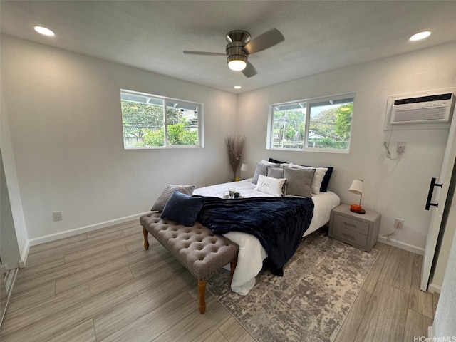 44-665 Kaneohe Bay Dr, Kaneohe, HI 96744 - bedroom featuring multiple windows, a wall mounted AC, light wood-type flooring, baseboards, and recessed lighting