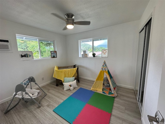 44-665 Kaneohe Bay Dr, Kaneohe, HI 96744 - game room featuring healthy amount of natural light, a textured ceiling, a ceiling fan, baseboards, and wood finished floors