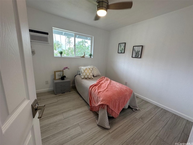 44-665 Kaneohe Bay Dr, Kaneohe, HI 96744 - bedroom featuring a wall mounted AC, light wood-style flooring, ceiling fan, and baseboards