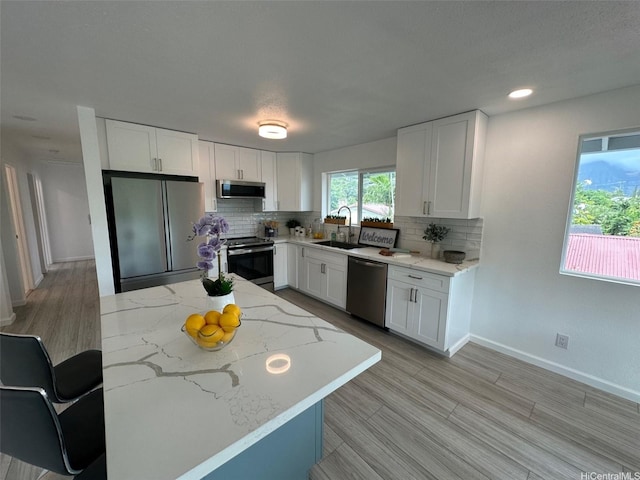 44-665 Kaneohe Bay Dr, Kaneohe, HI 96744 - kitchen featuring stainless steel appliances, tasteful backsplash, light stone counters, white cabinets, and recessed lighting