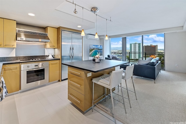1200 Queen Emma St Unit 1401, Honolulu, HI 96813 - kitchen featuring exhaust hood, a breakfast bar area, open floor plan, dark countertops, and appliances with stainless steel finishes
