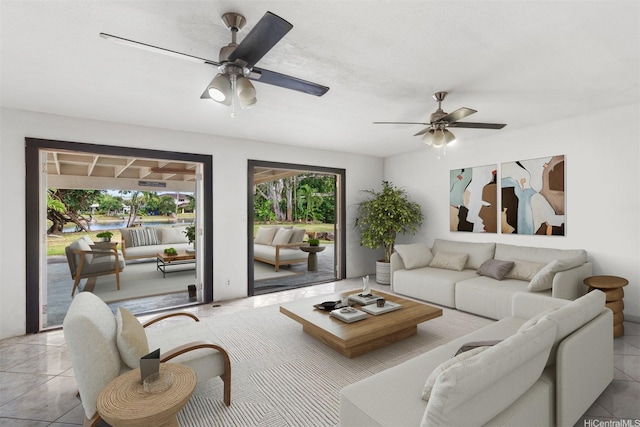living area with a ceiling fan and light tile patterned floors