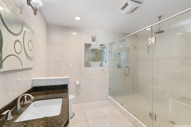 bathroom featuring toilet, tile walls, visible vents, tile patterned flooring, and a shower stall