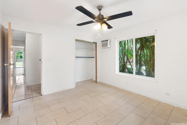 unfurnished bedroom featuring ceiling fan, a closet, light tile patterned floors, and a wall unit AC