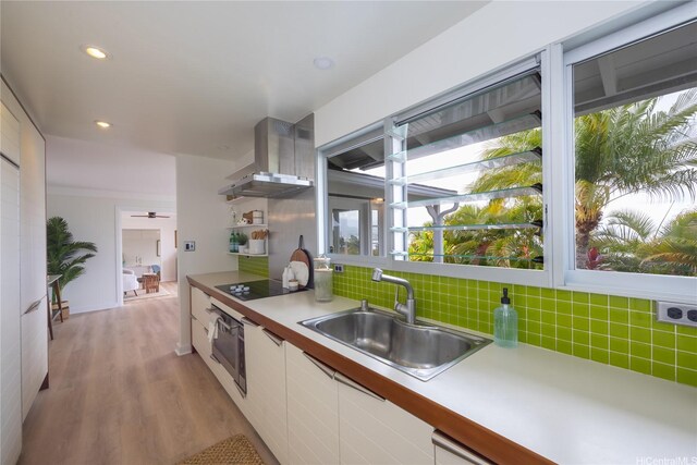 44-102 Kauinohea Pl, Kaneohe, HI 96744 - kitchen featuring wall chimney exhaust hood, wall oven, a sink, black electric stovetop, and tasteful backsplash