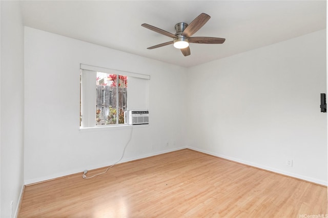 empty room with wood finished floors, a ceiling fan, and baseboards