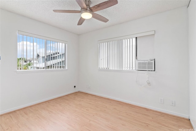 unfurnished room featuring wood finished floors, a textured ceiling, baseboards, and a ceiling fan