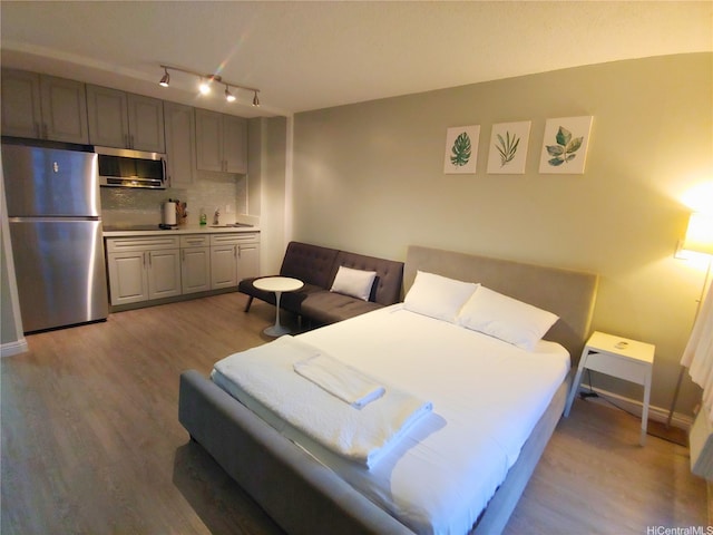 2345 Ala Wai Blvd Unit 1010, Honolulu, HI 96815 - bedroom with freestanding refrigerator, light wood finished floors, rail lighting, and a sink