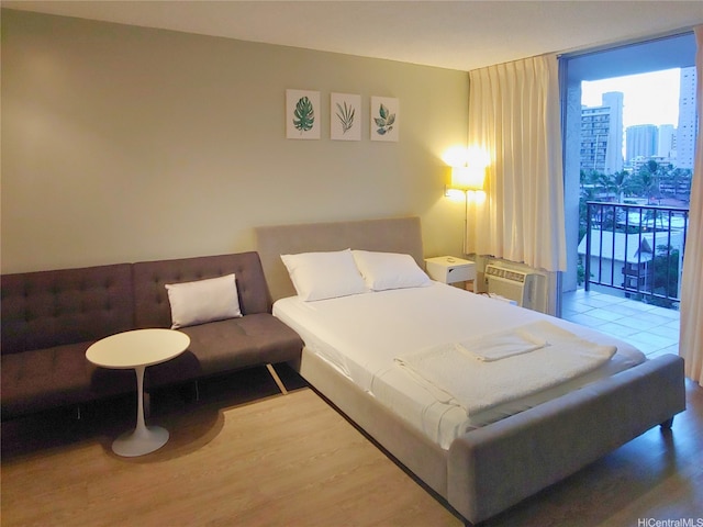 2345 Ala Wai Blvd Unit 1010, Honolulu, HI 96815 - bedroom with expansive windows, access to outside, a wall unit AC, and wood finished floors