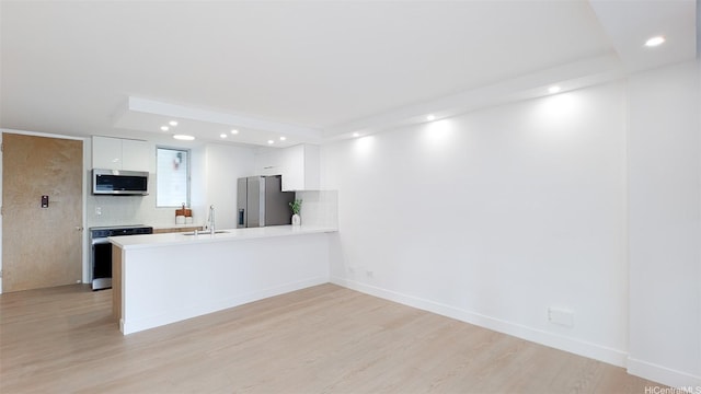 kitchen featuring a sink, a peninsula, stainless steel appliances, and recessed lighting