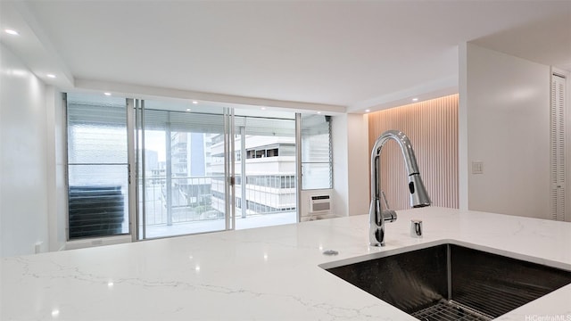kitchen featuring a sink, light stone countertops, and recessed lighting