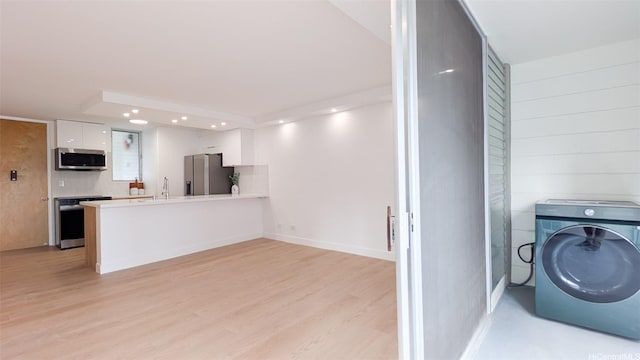 laundry room with light wood finished floors, washer / clothes dryer, recessed lighting, and a sink