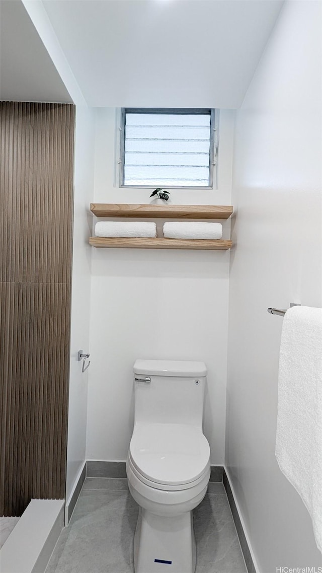 bathroom with toilet and baseboards