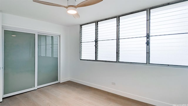 unfurnished bedroom featuring baseboards, a closet, light wood-style flooring, and a ceiling fan