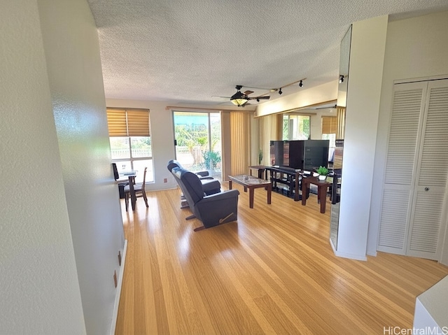 91-1012 Laaulu St Unit 28A, Ewa Beach, HI 96706 - living area featuring rail lighting, ceiling fan, light wood-style flooring, and a textured ceiling