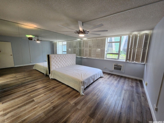 2500 Kalakaua Ave Unit 201, Honolulu, HI 96815 - bedroom featuring a wall mounted air conditioner, a textured ceiling, wood finished floors, and baseboards