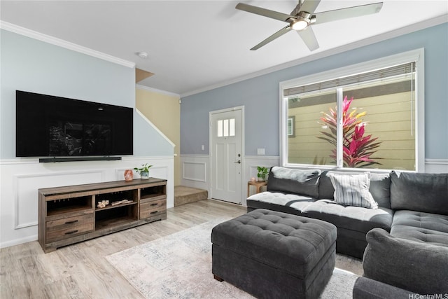living room featuring wainscoting, crown molding, ceiling fan, and wood finished floors