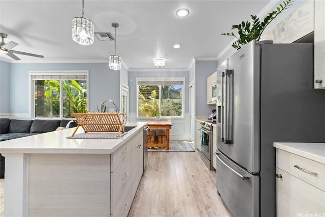 kitchen with visible vents, crown molding, light wood-style flooring, light countertops, and appliances with stainless steel finishes
