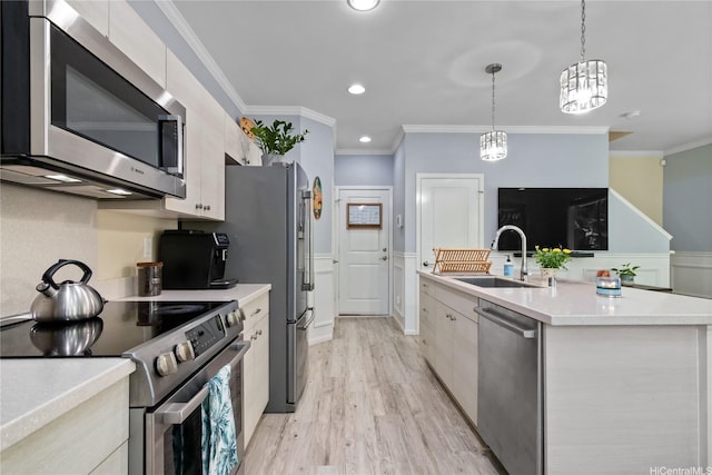 kitchen featuring ornamental molding, light countertops, stainless steel appliances, and a sink