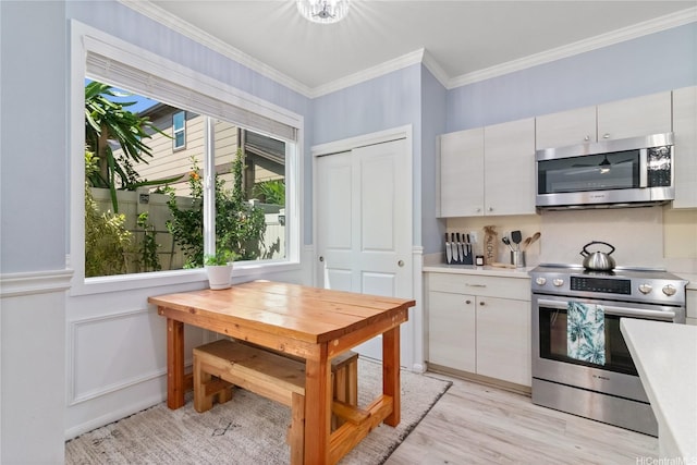 kitchen featuring light countertops, stainless steel appliances, plenty of natural light, and light wood-style floors