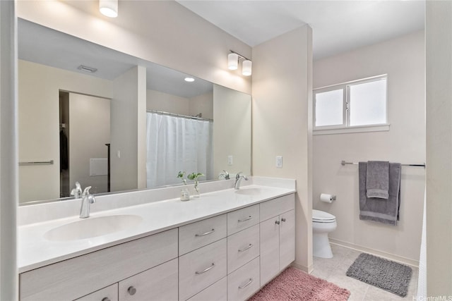 full bath featuring toilet, baseboards, double vanity, and a sink