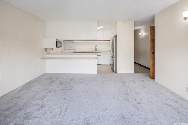 1687 Pensacola St Unit 804, Honolulu, HI 96822 - kitchen with a sink, white cabinetry, freestanding refrigerator, light colored carpet, and light countertops