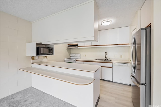 1687 Pensacola St Unit 804, Honolulu, HI 96822 - kitchen featuring white appliances, a textured ceiling, a peninsula, a sink, and white cabinetry