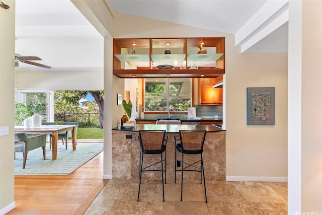 2055 Alihilani Pl, Honolulu, HI 96822 - bar featuring ceiling fan, backsplash, and vaulted ceiling