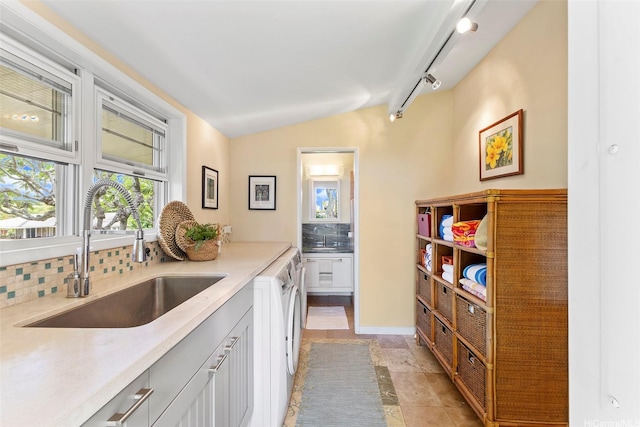 2055 Alihilani Pl, Honolulu, HI 96822 - kitchen featuring backsplash, washing machine and dryer, vaulted ceiling, and white cabinets