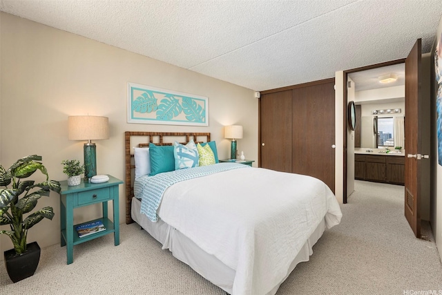 bedroom featuring connected bathroom, light carpet, a textured ceiling, and a closet