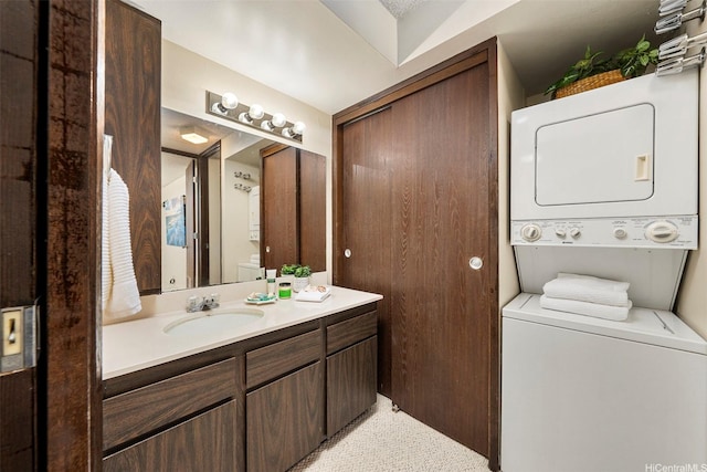 bathroom with stacked washer / dryer and vanity