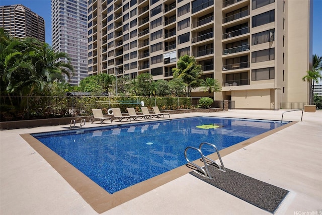community pool featuring a patio and fence