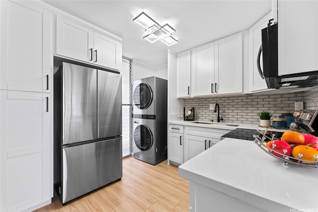 95-2031 Waikalani Pl Unit D306, Mililani, HI 96789 - kitchen featuring freestanding refrigerator, stacked washer / dryer, white cabinets, and backsplash