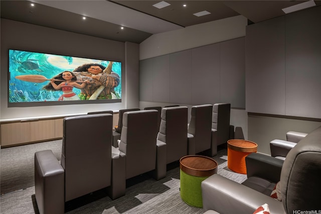 cinema room featuring light carpet and vaulted ceiling