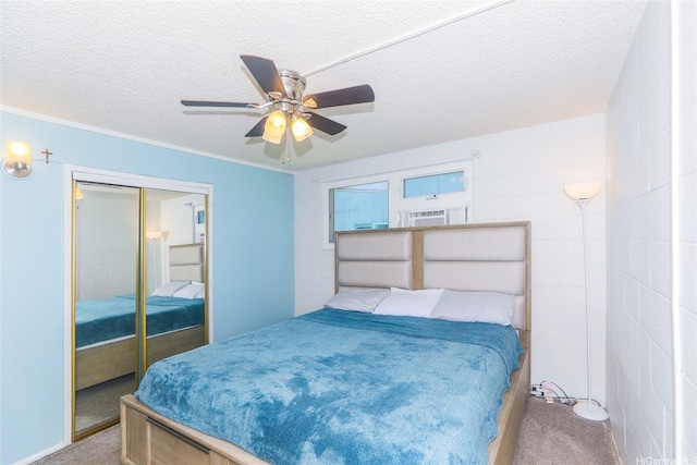 bedroom with a textured ceiling, carpet floors, a closet, and a ceiling fan