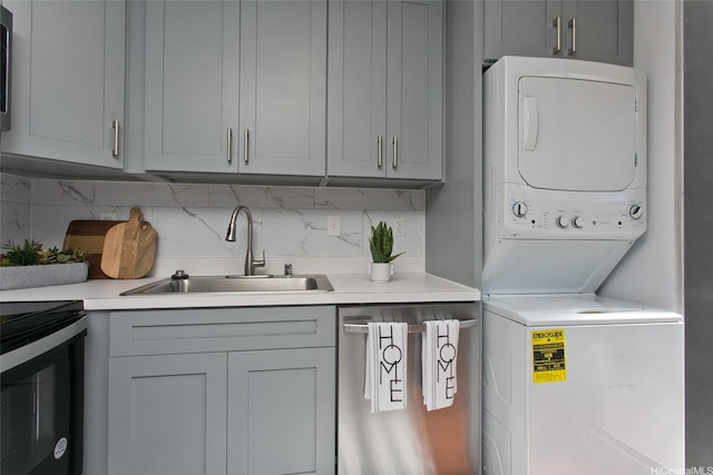 laundry room featuring laundry area, a sink, and stacked washer and dryer