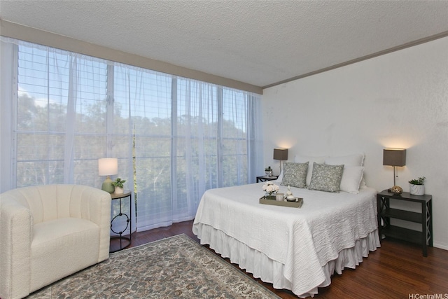 bedroom with baseboards, ornamental molding, a textured ceiling, and wood finished floors