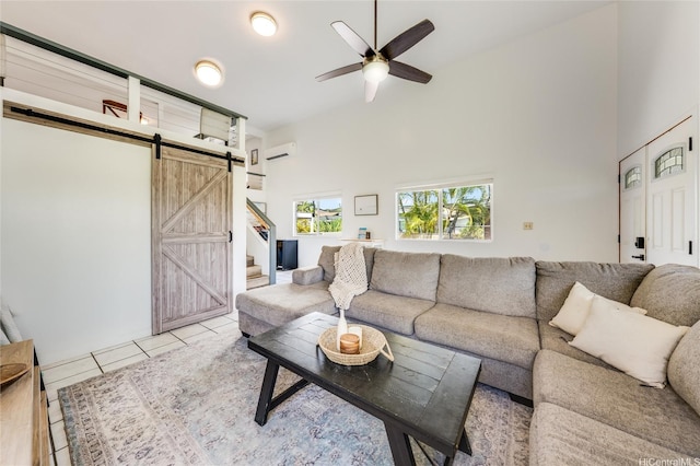 625 Maluniu Ave, Kailua, HI 96734 - tiled living area featuring a barn door, a wall unit AC, ceiling fan, and high vaulted ceiling
